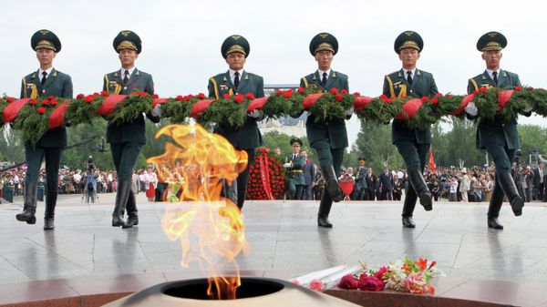 Officers lay flowers to the Eternal Flame during the Victory Day celebration in Bishkek's Victory Square Officers lay flowers to the Eternal Flame during the Victory Day celebration in Bishkek's Victory Square - Sputnik International