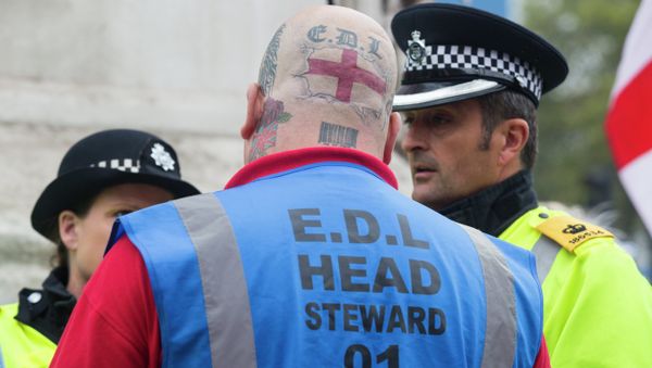 A supporter of the far-right English Defence League (EDL) speaks with police during a march in London on September 20, 2014 A supporter of the far-right English Defence League (EDL) speaks with police during a march in London on September 20, 2014 - Sputnik International