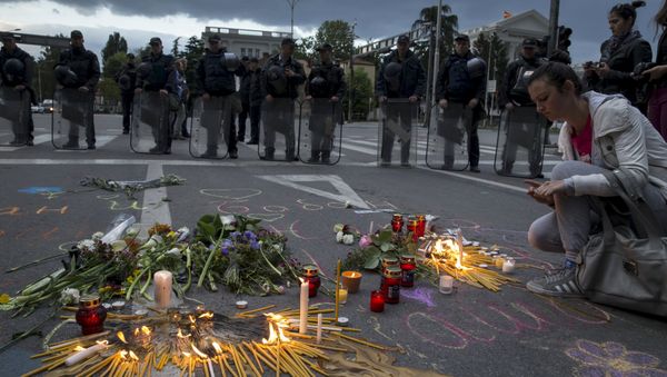 A woman lights a candle to commemorate policemen who were killed in a gun battle, during a memorial in Skopje, Macedonia, May 11, 2015. A woman lights a candle to commemorate policemen who were killed in a gun battle, during a memorial in Skopje, Macedonia, May 11, 2015. - Sputnik International