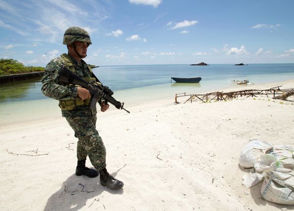 A Filipino soldier patrols the shore of disputed Pag-asa Island in the South China Sea. - Sputnik International