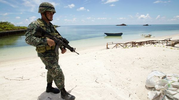 A Filipino soldier patrols the shore of disputed Pag-asa Island in the South China Sea. A Filipino soldier patrols the shore of disputed Pag-asa Island in the South China Sea. - Sputnik International