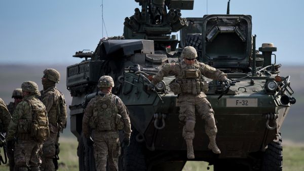 US Army serviceman jumps from armored vehicle during the NATO Wind Spring 15 military exercise at Smardan military shooting range on April 21, 2015 - Sputnik International