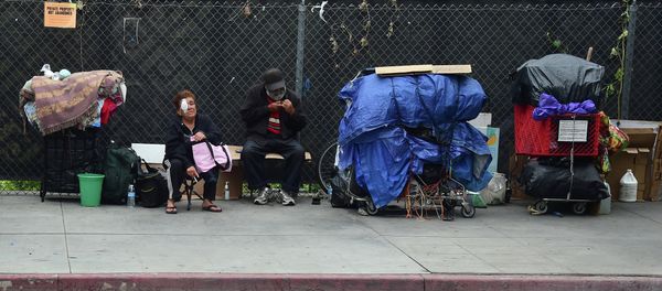 Homeless residents sit beside their belongings in downtown Los Angeles Homeless residents sit beside their belongings in downtown Los Angeles - Sputnik International