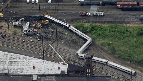 Emergency personnel work at the scene of a deadly train derailment, Wednesday, May 13, 2015, in Philadelphia - Sputnik International