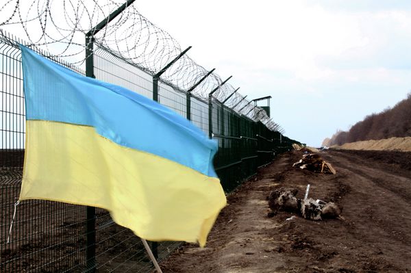 A Ukrainian national flag is attached to the fence on the Ukrainian-Russian border near Hoptivka, Kharkiv region, eastern Ukraine - Sputnik International