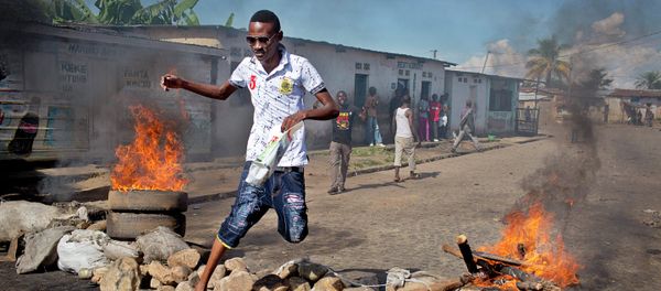 A civilian jumps over a burning barricade of rocks erected by residents to protect themselves from police, in a northern district of the capital Bujumbura, in Burundi Thursday, May 14, 2015 A civilian jumps over a burning barricade of rocks erected by residents to protect themselves from police, in a northern district of the capital Bujumbura, in Burundi Thursday, May 14, 2015 - Sputnik International