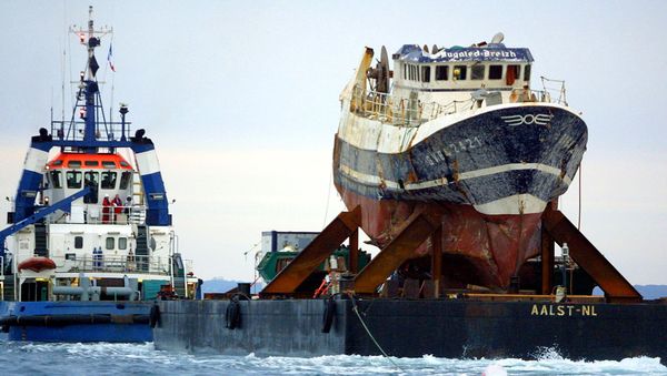 A picture taken on July 13, 2004 shows the wreckage of French trawler Bugaled Breizh, installed at a barge, as it is being towed, and escorted by military ships, towards a French military port of Brest. file photo A picture taken on July 13, 2004 shows the wreckage of French trawler Bugaled Breizh, installed at a barge, as it is being towed, and escorted by military ships, towards a French military port of Brest. file photo - Sputnik International