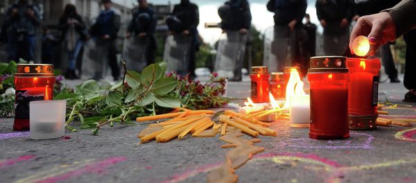 People light candles in front of the riot policemen to commemorate policemen who were killed after fighting between Macedonian police and an armed group in the town of Kumanovo , in Skopje on May 11, 2015 - Sputnik International