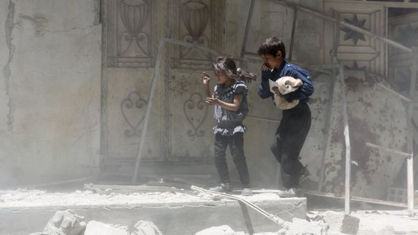 Children walk over rubble carrying a bag of bread after what activists said were airstrikes by warplanes loyal to Syria's President Bashar al-Assad in Erbeen, in the eastern Damascus suburb of Ghouta May 15, 2015 - Sputnik International