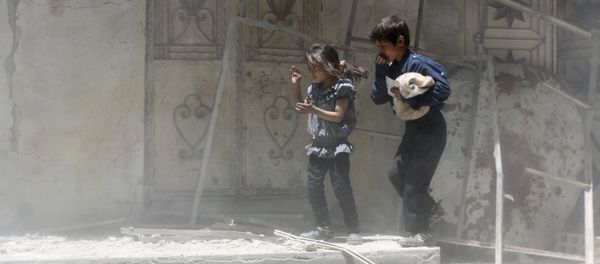 Children walk over rubble carrying a bag of bread after what activists said were airstrikes by warplanes loyal to Syria's President Bashar al-Assad in Erbeen, in the eastern Damascus suburb of Ghouta May 15, 2015 - Sputnik International