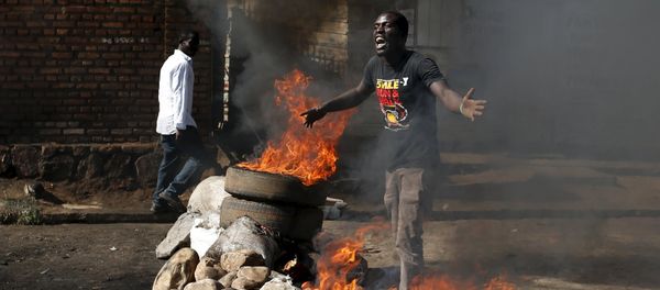 A protester, who is against President Pierre Nkurunziza's decision to run for a third term, gestures in front of a burning barricade in Bujumbura, Burundi May 14, 2015 A protester, who is against President Pierre Nkurunziza's decision to run for a third term, gestures in front of a burning barricade in Bujumbura, Burundi May 14, 2015 - Sputnik International