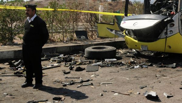 An Egyptian policeman stands guard next to wreckage of a bus that was targeted the day before by a bomb in the Egyptian south Sinai resort town of Taba on February 17, 2014 - Sputnik International