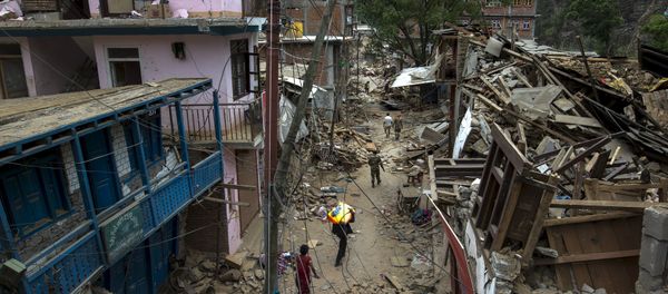 Local residents walk past collapsed buildings after Tuesday's earthquake at Singati Village, in Dolakha, Nepal, May 15, 2015 - Sputnik International