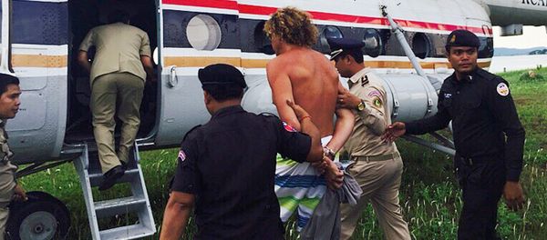 Russian Sergei Polonsky (C) is escorted by Cambodian police officials into a helicopter on an island in Preah Sihanouk province on May 15, 2015 - Sputnik International