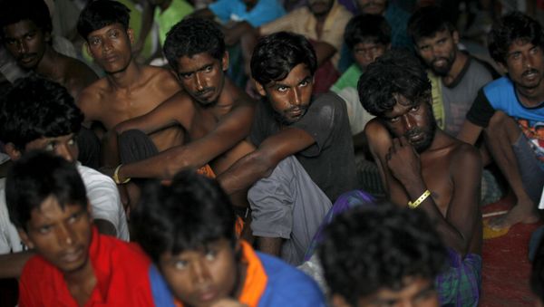 In this Sunday, May 17, 2015, file photo, Bangladeshi men listen during a visit by Bangladesh's Ambassador to Indonesia Mohammad Nazmul Quaunine at a temporary shelter in Langsa, Aceh province, Indonesia In this Sunday, May 17, 2015, file photo, Bangladeshi men listen during a visit by Bangladesh's Ambassador to Indonesia Mohammad Nazmul Quaunine at a temporary shelter in Langsa, Aceh province, Indonesia - Sputnik International