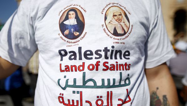 A member of the faithful wears a t-shirt with the pictures of the two Palestinian nuns being canonised before Pope Francis leads a ceremony for the canonisation of four nuns at Saint Peter's square in the Vatican City, May 17, 2015 A member of the faithful wears a t-shirt with the pictures of the two Palestinian nuns being canonised before Pope Francis leads a ceremony for the canonisation of four nuns at Saint Peter's square in the Vatican City, May 17, 2015 - Sputnik International