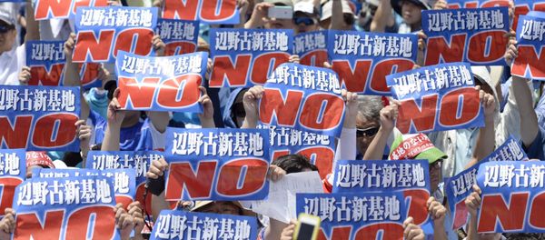 Protesters raise placards during a rally to oppose the transfer of a key U.S. military base within the prefecture, at a baseball stadium in the prefectural capital Naha on Japan's southern island of Okinawa, in this photo taken by Kyodo May 17, 2015 Protesters raise placards during a rally to oppose the transfer of a key U.S. military base within the prefecture, at a baseball stadium in the prefectural capital Naha on Japan's southern island of Okinawa, in this photo taken by Kyodo May 17, 2015 - Sputnik International