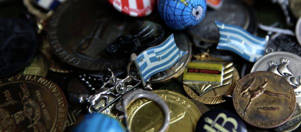 A badge with the Greek flag, center, and other badges and pins. A badge with the Greek flag, center, and other badges and pins. - Sputnik International