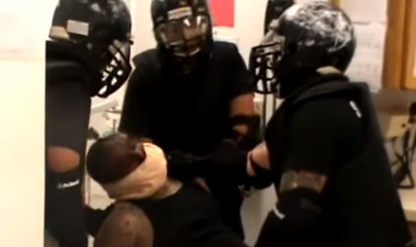 Sgt. James Brown is pictured here surrounded by officers, handcuffed and wearing a spit mask, which he repeatedly asked to have removed because he was having trouble breathing. - Sputnik International