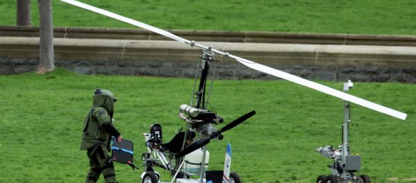 A member of a bomb squad checks a small helicopter after a man landed on the West Lawn of the Capitol in Washington, Wednesday, April 15, 2015. A member of a bomb squad checks a small helicopter after a man landed on the West Lawn of the Capitol in Washington, Wednesday, April 15, 2015. - Sputnik International