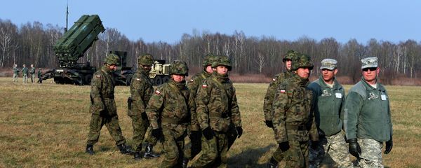 Polish soldiers watch as US troops from the 5th Battalion of the 7th Air Defense Regiment emplace a launching station of the Patriot air and missile defence system at a test range in Sochaczew, Poland - Sputnik International