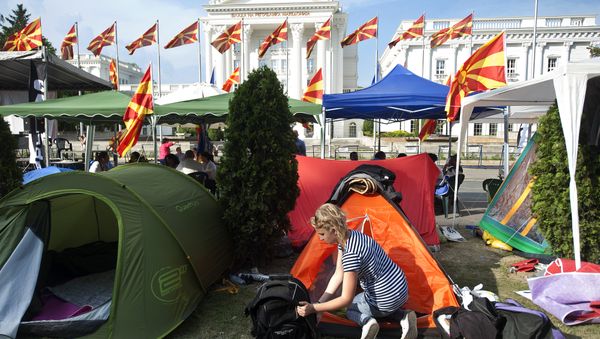 A woman stands next to her tent in a makeshift camp in front of the government building where protesters have said they will not leave until the government resigns, in Skopje A woman stands next to her tent in a makeshift camp in front of the government building where protesters have said they will not leave until the government resigns, in Skopje - Sputnik International