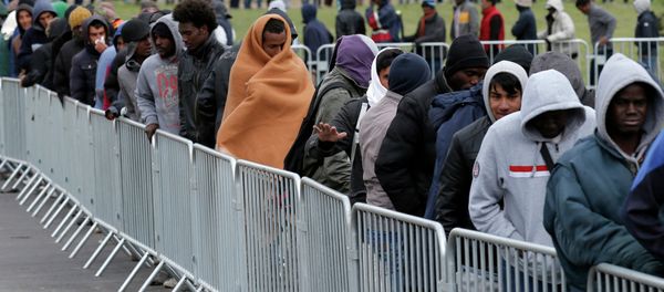 Migrants queue to receive their daily food distribution at the Jules Ferry center for migrants, in the outskirts of Calais, northern France. - Sputnik International