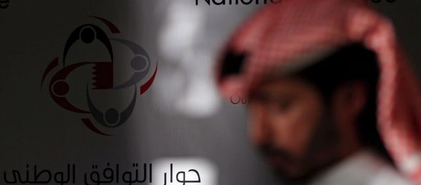 A Bahraini man walks past a display that reads, national dialogue in Arabic and English. A Bahraini man walks past a display that reads, national dialogue in Arabic and English. - Sputnik International