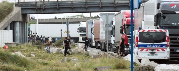 Policemen stand guard next to truck queuing to board a ferry to Great Britain to prevent migrants to reach the UK illegally, on September 10, 2014 in the French port of Calais Policemen stand guard next to truck queuing to board a ferry to Great Britain to prevent migrants to reach the UK illegally, on September 10, 2014 in the French port of Calais - Sputnik International