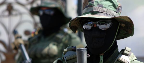 Iraqi fighters of the Shiite militia Asaib Ahl al-Haq (The League of the Righteous) stand guard outside their headquarters on May 18, 2015 - Sputnik International