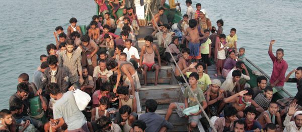 In this Wednesday, May 20, 2015 file photo, migrants wait to be be rescued by Acehnese fishermen on their boat on the sea off East Aceh, Indonesia In this Wednesday, May 20, 2015 file photo, migrants wait to be be rescued by Acehnese fishermen on their boat on the sea off East Aceh, Indonesia - Sputnik International