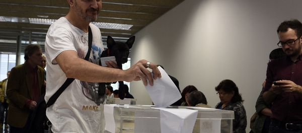 A man carrying a dog casts his ballots in the Spain's municipal and regional elections at a polling station in Barcelona on May 24, 2015 A man carrying a dog casts his ballots in the Spain's municipal and regional elections at a polling station in Barcelona on May 24, 2015 - Sputnik International