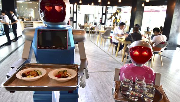Robot couple Xiaolan (L) and Xiaotao carry trays of food at a restaurant in Jinhua, Zhejiang province, China, May 18, 2015 - Sputnik International