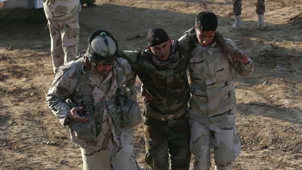 Iraqi soldiers help a wounded comrade in the area of Sayed Ghareeb, near Dujail, some 70 kilometres north of Baghdad Iraqi soldiers help a wounded comrade in the area of Sayed Ghareeb, near Dujail, some 70 kilometres north of Baghdad - Sputnik International