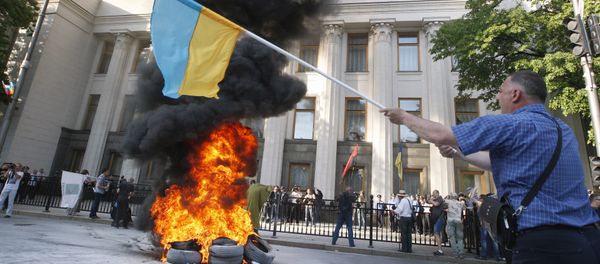 Protesters burn tires during a rally supporting a law on the restructuring of foreign currency loans in front of the Ukrainian Parliament in Kiev on May 21, 2015 Protesters burn tires during a rally supporting a law on the restructuring of foreign currency loans in front of the Ukrainian Parliament in Kiev on May 21, 2015 - Sputnik International