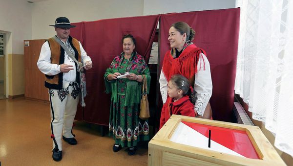 People wearing traditional outfits prepare to cast their ballots during the second round of presidential elections at a polling station in Zakopane, Poland May 24, 2015 People wearing traditional outfits prepare to cast their ballots during the second round of presidential elections at a polling station in Zakopane, Poland May 24, 2015 - Sputnik International