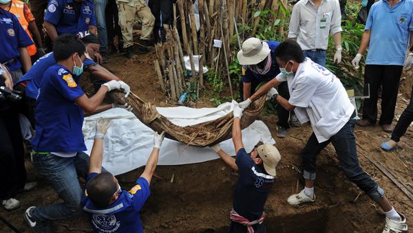 Rescue workers and forensic officials dig out skeletons from shallow graves Rescue workers and forensic officials dig out skeletons from shallow graves - Sputnik International