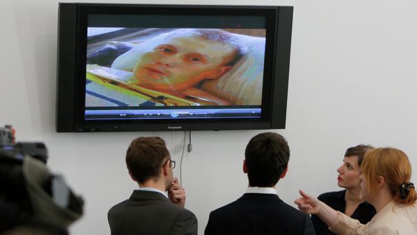 Reporters look at the TV screen showing Alexander Alexandrov, a Russian ex-soldier captured by the Ukrainian military in the Luhansk region last month. - Sputnik International