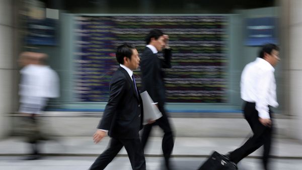 People walk past an electronic stock board of a securities firm in Tokyo. People walk past an electronic stock board of a securities firm in Tokyo. - Sputnik International
