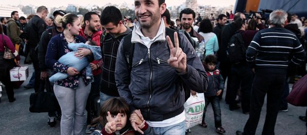 A migrant from Syria and his child flash a victory sign as they arrive from the eastern Aegean island of Lesvos at the port of Piraeus, near Athens A migrant from Syria and his child flash a victory sign as they arrive from the eastern Aegean island of Lesvos at the port of Piraeus, near Athens - Sputnik International