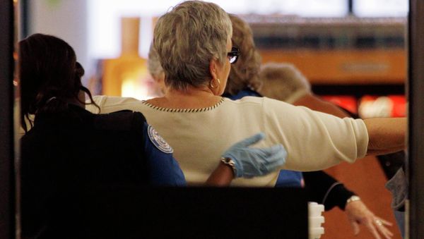 A TSA officer searches a passenger at a security check-point. - Sputnik International