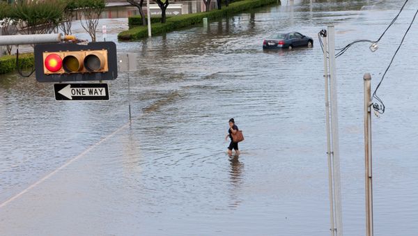 A woman walks in the flood waters in southwest Houston, Texas May 26, 2015 A woman walks in the flood waters in southwest Houston, Texas May 26, 2015 - Sputnik International