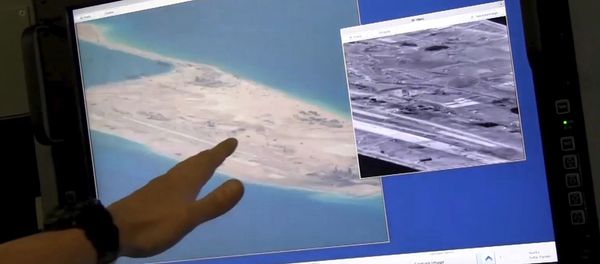 US Navy crewman aboard a P-8A Poseidon surveillance aircraft points to a computer screen purportedly showing Chinese construction on the reclaimed land of Fiery Cross Reef in the disputed Spratly Islands in the South China Sea in this still image from video provided by the United States Navy May 21, 2015 - Sputnik International