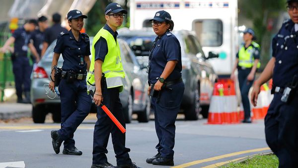 Singapore policemen secure an entry point as they stop pedestrians and attendees of the 14th International Institute for Strategic Studies Shangri-la Dialogue, or IISS, Asia Security Summit, from entering the vicinity, Sunday, May 31, 2015, in Singapore - Sputnik International
