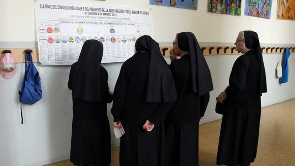 Nuns watch a list of candidates prior to cast their ballots for Italian regional elections in seven of the twenty country's regions and more than 700 municipalities, at a polling station in Vicenza, Italy, Sunday, May 31, 2015 - Sputnik International