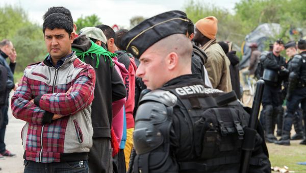 Police watch migrants gathered outside the Jules Ferry day care center for migrant Police watch migrants gathered outside the Jules Ferry day care center for migrant - Sputnik International