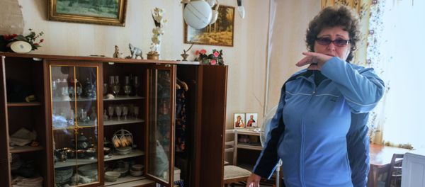 Donetsk. A woman at her apartment inside a building damaged by Ukrainian forces Donetsk. A woman at her apartment inside a building damaged by Ukrainian forces - Sputnik International