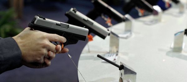 A firearms retailer examines a Smith & Wesson 9mm pistol at the Shooting, Hunting and Outdoor Trade show, Jan. 18, 2011, in Las Vegas A firearms retailer examines a Smith & Wesson 9mm pistol at the Shooting, Hunting and Outdoor Trade show, Jan. 18, 2011, in Las Vegas - Sputnik International