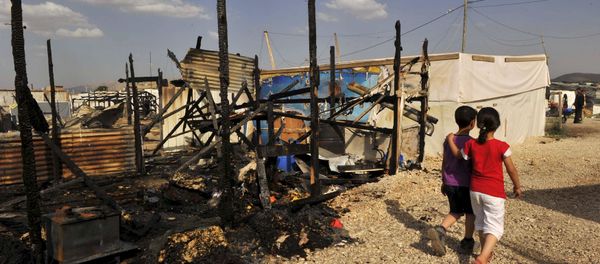 Children walk near the remains of tents that were burnt in a refugee camp for Syrian refugees in Lebanon's Bekaa Valley June 1, 2015. Children walk near the remains of tents that were burnt in a refugee camp for Syrian refugees in Lebanon's Bekaa Valley June 1, 2015. - Sputnik International