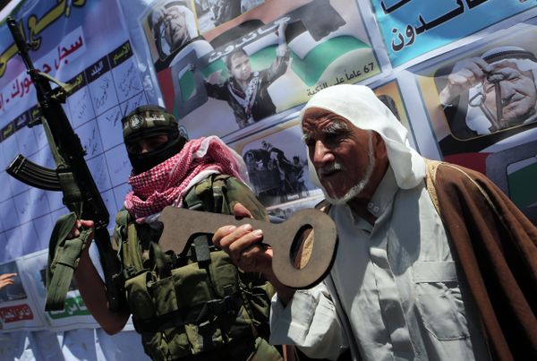 Palestinian militants of the Ezzedine al-Qassam Brigades, Hamas' armed wing, stand with an old Palestinian man holding a wooden key during a parade in the southern Gaza Strip town of Rafah on May 17, 2015 to mark the 67th anniversary of the Nakba Palestinian militants of the Ezzedine al-Qassam Brigades, Hamas' armed wing, stand with an old Palestinian man holding a wooden key during a parade in the southern Gaza Strip town of Rafah on May 17, 2015 to mark the 67th anniversary of the Nakba - Sputnik International